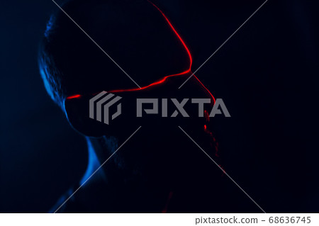 Man in dark with face illuminated by scan red laser on contour Man in dark with face illuminated by scan red laser on contour 68636745