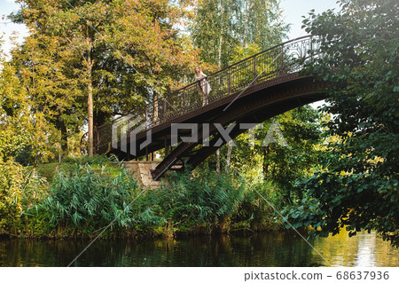 Beautiful and young girl stands on the wooden Beautiful and young girl stands on the wooden 68637936