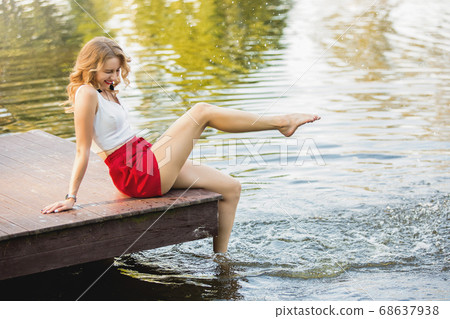happy attractive young woman at a lake having fun happy attractive young woman at a lake having fun 68637938
