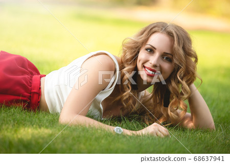 Top view of attractive female model lying on green 68637941