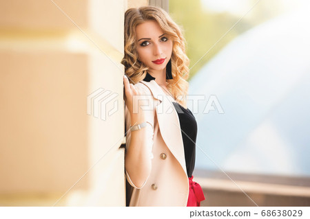 Beautiful young girl standing near the stone wall. 68638029