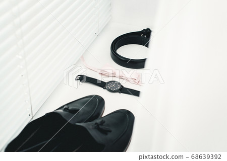 Close up of modern man accessories. beige bow tie, black leather shoes, belt and watch Close up of modern man accessories. beige bow tie, black leather shoes, belt and watch 68639392