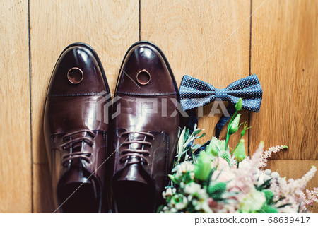 blue bow tie, leather shoes and wedding rings. Grooms wedding morning. Close up of modern man accessories 68639417
