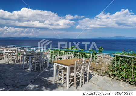 Chalkidiki, Greece empty tavern wooden chairs & table after new covid-19 measures. 68640587