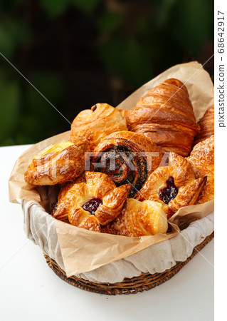 Closeup on variety of sweet baked buns in a basket Closeup on variety of sweet baked buns in a basket 68642917