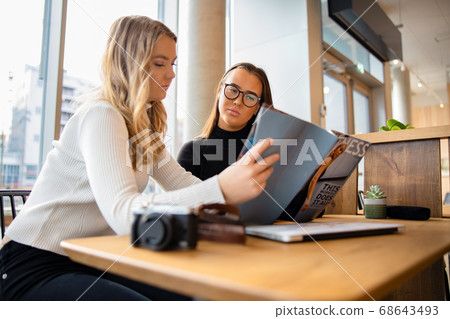 Serious Young Bloggers Discussing Over Publication In Cafe Serious Young Bloggers Discussing Over Publication In Cafe 68643493