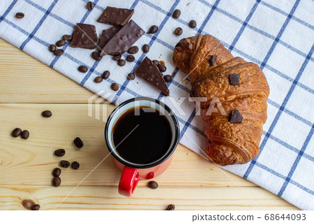 Coffee and a croissant on a wooden background. 68644093
