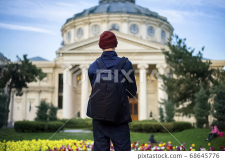 Man with backpack in front of Romanian Athenaeum 68645776