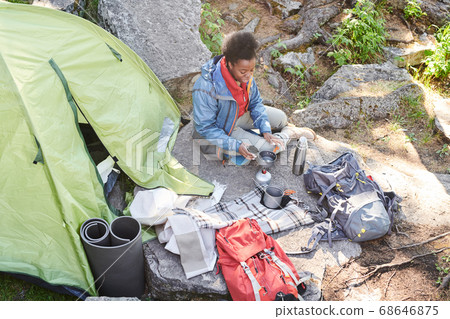 Woman drinking tea during camping Woman drinking tea during camping 68646875