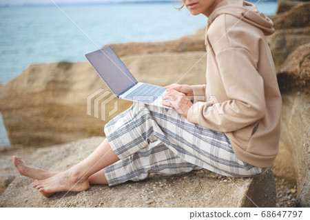 girl with a laptop by the sea. remote work concept 68647797