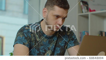 Young man using a laptop to send work emails, shop online to navigate on social networks or e-learning. 68648004