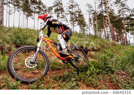 downhill mountain biker on forest trail 68648310