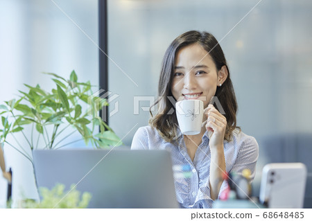 A woman taking a break at the desk A woman taking a break at the desk 68648485