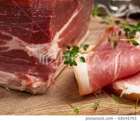 chopped into pieces of prosciutto on a brown 68648703