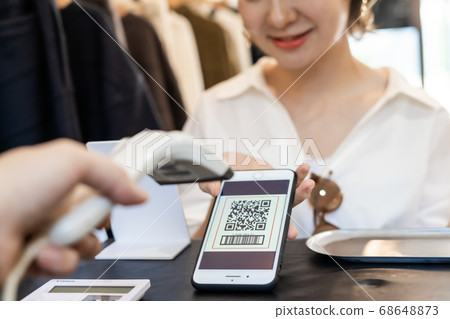 年輕女子用QR碼付款 年輕女子用QR碼付款 68648873