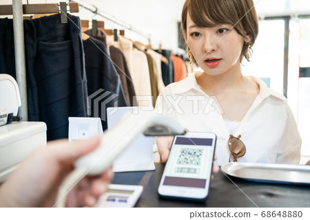 Young woman paying with QR code payment Young woman paying with QR code payment 68648880