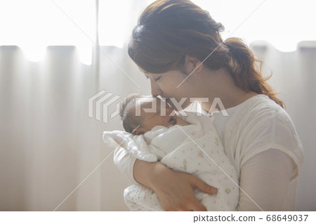 Mother holding a newborn baby Mother holding a newborn baby 68649037