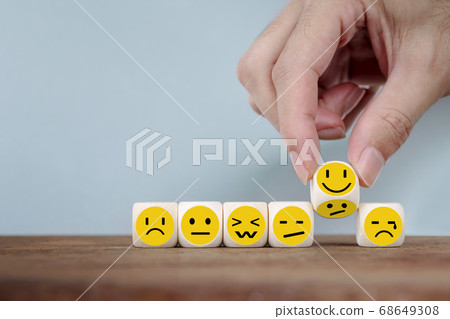 Hand Changing with smile emoticon icons face on Wooden Cube , hand flipping unhappy turning to happy symbol Hand Changing with smile emoticon icons face on Wooden Cube , hand flipping unhappy turning to happy symbol 68649308