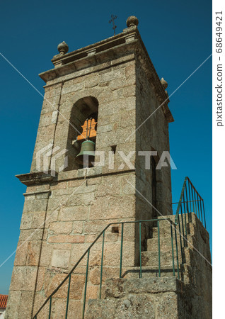 Medieval steeple made of stone with bell 68649421