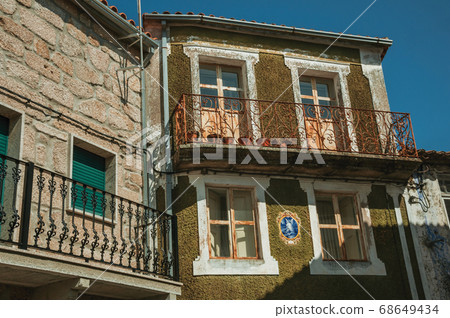 Old houses and balcony with wrought iron railing Old houses and balcony with wrought iron railing 68649434