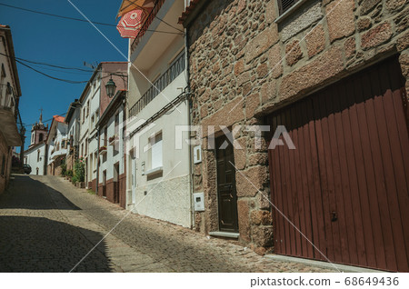Old houses in a deserted alley on slope 68649436