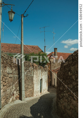 Narrow deserted alley with worn plaster walls Narrow deserted alley with worn plaster walls 68649452