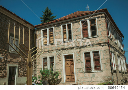 Stone house and metal sculpture in menorah shape Stone house and metal sculpture in menorah shape 68649454