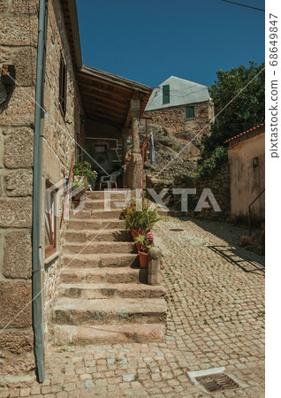 Old house with stone staircase and flower pots 68649847