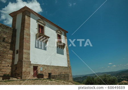 Building with stone and whitewashed wall at the Belmonte Castle 68649889