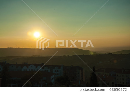 Landscape and several wind turbines silhouettes on sunset Landscape and several wind turbines silhouettes on sunset 68650372
