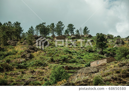 Rustic stone house on a hilly landscape Rustic stone house on a hilly landscape 68650380