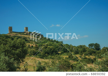 Hilly landscape with the towers of Linhares da Beira Castle 68650392