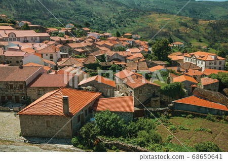 Hilly landscape with the roofs from village Hilly landscape with the roofs from village 68650641