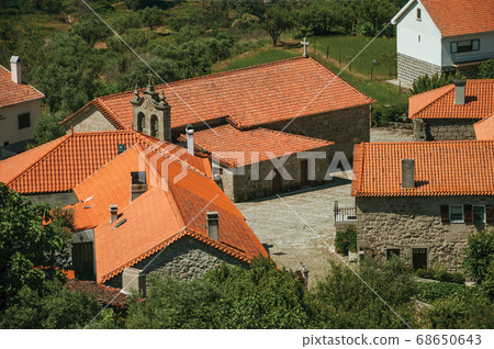 Hilly landscape with the roofs from village 68650643