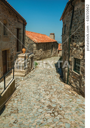 Cobblestone alley on slope and stone old houses Cobblestone alley on slope and stone old houses 68650662