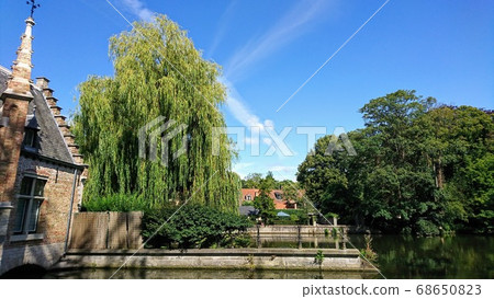A blue sky spread over Bruges full of greenery 68650823