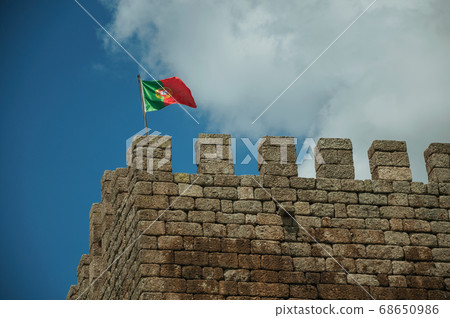 Portuguese flag fluttering on top of tower Portuguese flag fluttering on top of tower 68650986