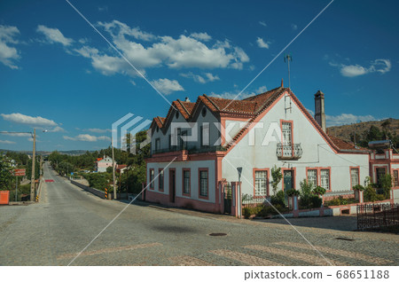 House next to a road passing through countryside landscape House next to a road passing through countryside landscape 68651188