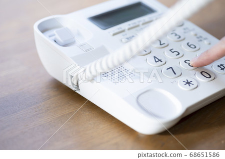 Female hand making a call from landline Female hand making a call from landline 68651586