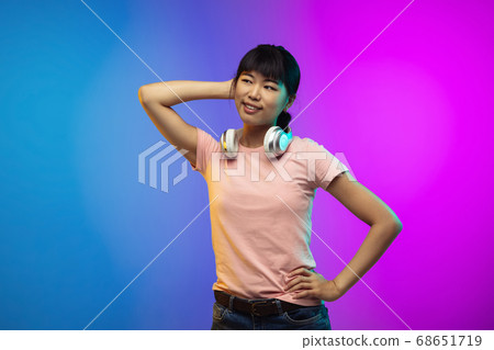 Asian young woman's portrait on gradient studio background in neon Asian young woman's portrait on gradient studio background in neon 68651719