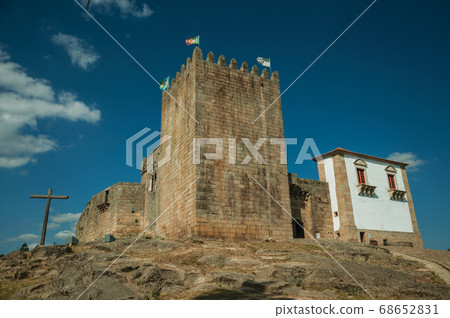 Castle and square tower over rocky hill with cross Castle and square tower over rocky hill with cross 68652831
