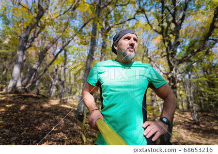 Portrait of a bearded athletic man engaged in slack next to a stretched sling for balance in the autumn forest. athlete 40 years old on a sunny day 68653216