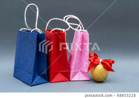 Golden Egg with red Ribbon and shopping bags isolated on gray background Golden Egg with red Ribbon and shopping bags isolated on gray background 68653228