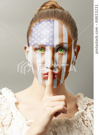 Young woman making a silence gesture with USA flag Young woman making a silence gesture with USA flag 68653231