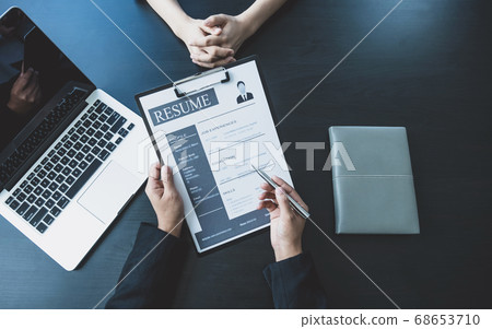 Business office executives are interviewing job applicants in the meeting room 68653710