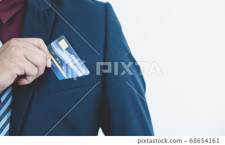 Businessman's hand put a credit card into a smart blue suit pocket 68654161