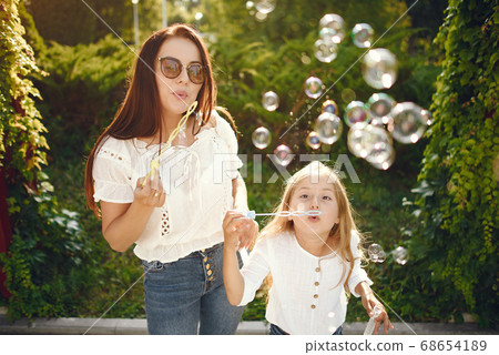 Mother with daughter playing in a summer paek 68654189