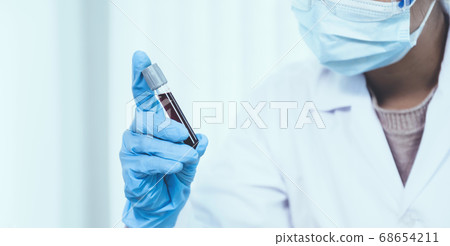 doctor's hand holding a sample blood tube for analysis and test virus disease in the laboratory 68654211