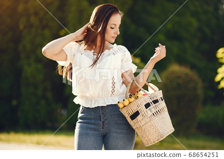 Elegant brunette in a summer park Elegant brunette in a summer park 68654251