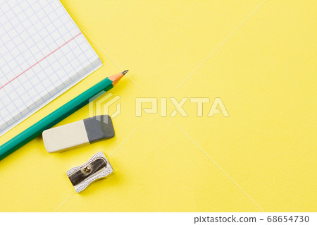 Notebook with a pencil on a yellow background. 68654730